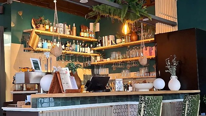 The bar at MidDay + Good Impressions, with espresso equipment below shelves of spirits and glassware